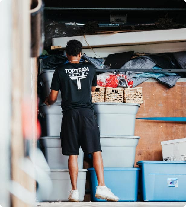 A man stacking boxes onto the moving truck.
